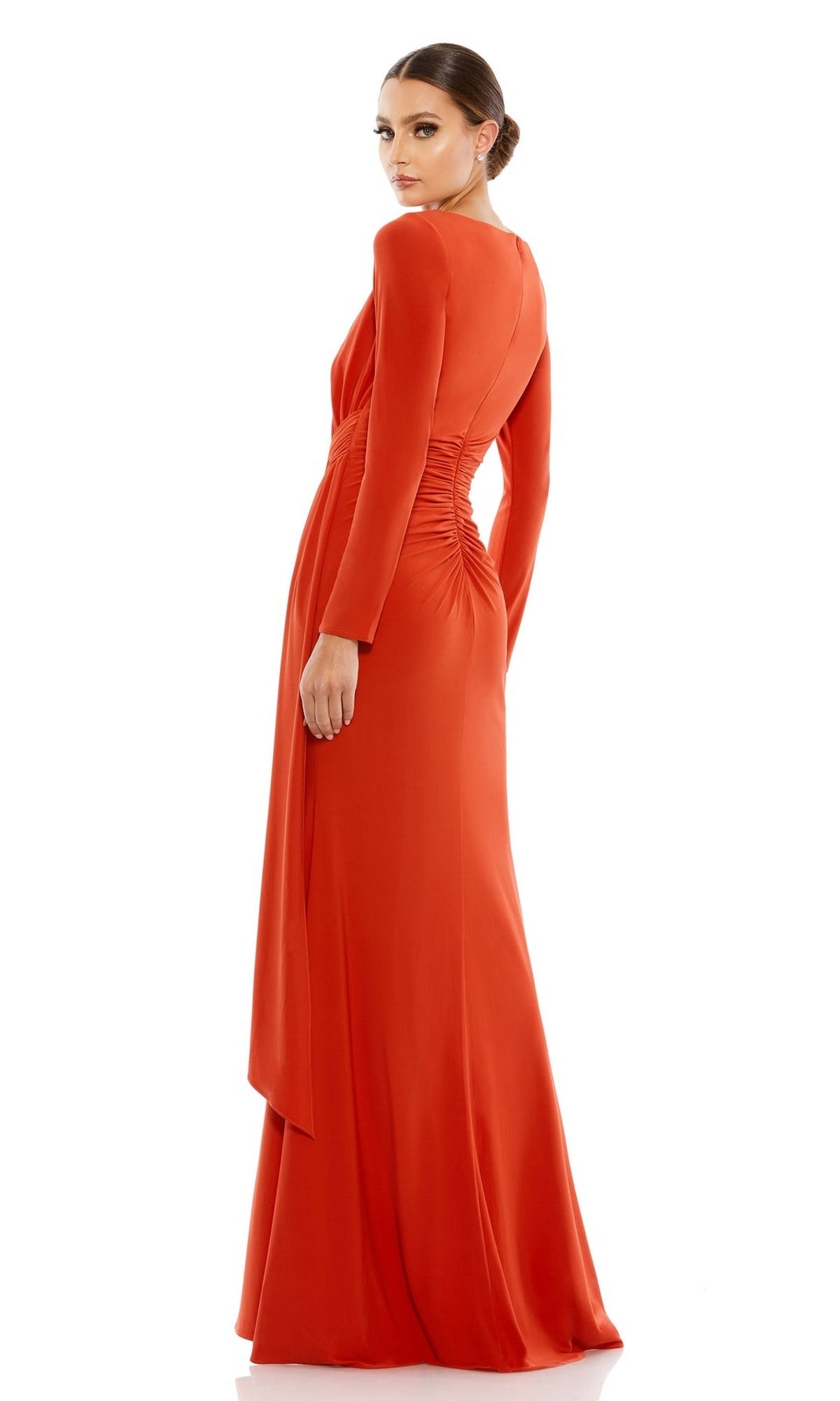 A woman faces away wearing the Long Formal Dress 26714 by Mac Duggal, an orange, floor-length gown with long sleeves, elegant waist ruching, and a smooth, flowing skirt.